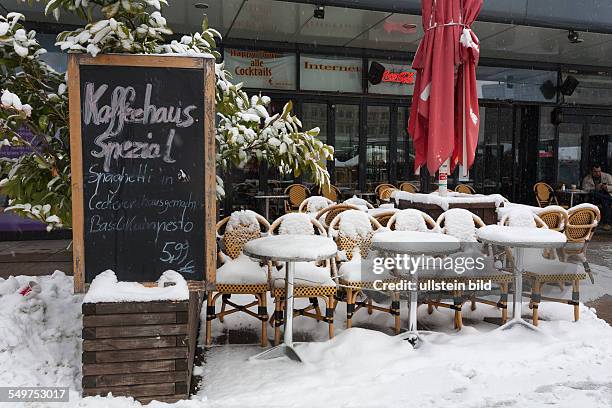 Germany - Berlin - Mitte: chairs and tables covered with snow in front of a cafe at square "Alexanderplatz"
