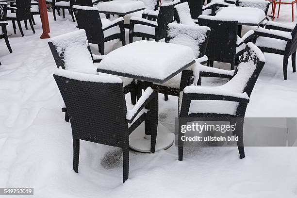 Germany - Berlin - Mitte: chairs and tables covered with snow in front of a cafe at square "Alexanderplatz"