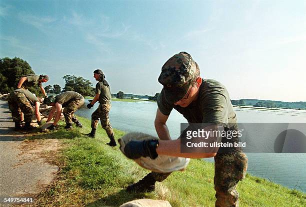 Bundeswehrsoldaten stapeln Sandsaecke auf dem Elbdamm bei Lenzen