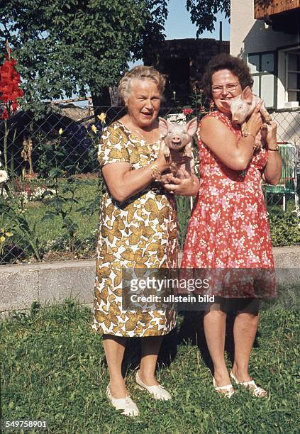 Ca. 1960, Zwei Frauen mit Ferkeln im Garten