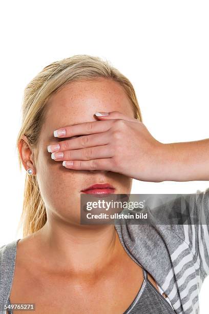 Eine junge Frau hält sich die Augen zu. Symbolfoto für nicht sehen wollen und Verdrängung