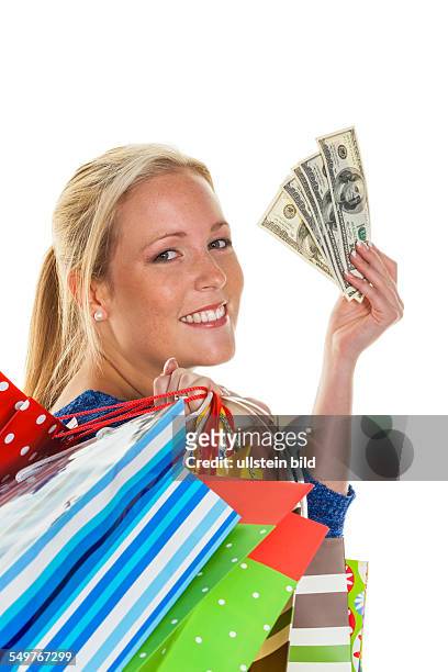 Eine junge Frau kommt mit vielen Einkaufstaschen vom Shopping zurück. Mit amerikanischen Dollars