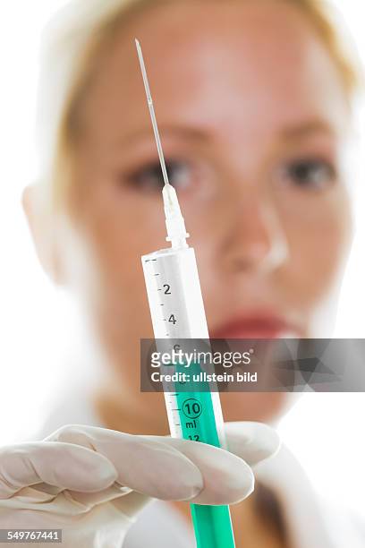 Eine junge Ärztin mit einer Spritze. Symbolfoto für Injektionen, Medizin und Impfungen