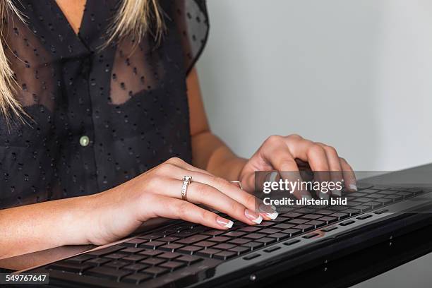 Eine Frau mit der Tastatur eines Computers. Arbeiten im Büro