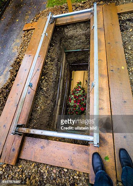Das offene, frische Grab mit Sarg auf einem Friedhof. Nach dem Begräbnis