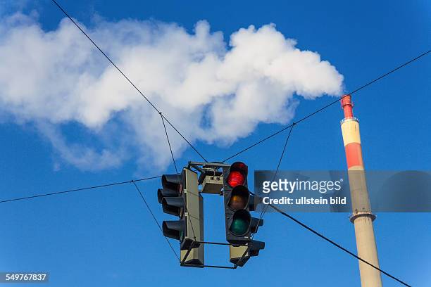 Schlot eines Industriebetriebes und roter Ampel. Symbolfoto für Umweltschutz und Ozon.