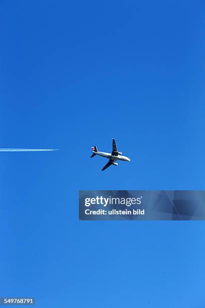 Deutschland, Flugzeug im Anflug auf den Flughafen Kloten in der Schweiz ueber deutsches Grenzgebiet, weiters Flugzeug mit Kondessreifen im Hintergrund