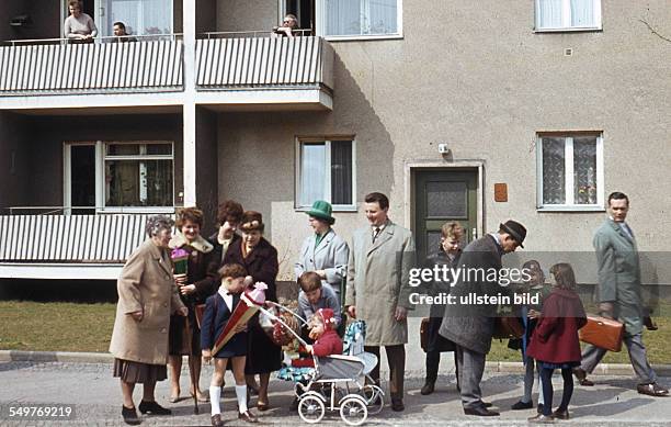 Ca. 1964, Schulanfang, Scchulanfänger mit Schultüten im Kreis der Familie und Nachbarn auf der Strasse vor einem Wohnhaus