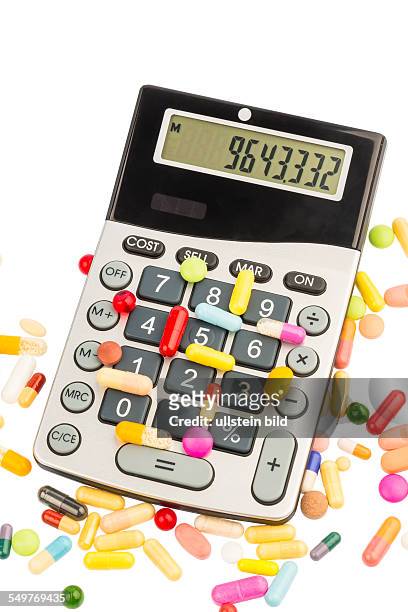 Tabletten liegen auf einem Taschenrechner. Symbolfoto für Kosten in der Medizin und Pharmaindustrie