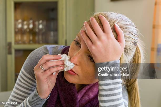 Frau im Krankenstand mit Taschentuch und Medikamenten. Erkältung, Schnupfen und Grippezeit