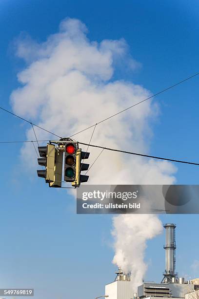 Schlot eines Industriebetriebes und roter Ampel. Symbolfoto für Umweltschutz und Ozon.