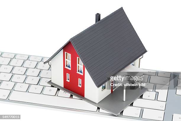Wohnhaus auf Tastatur, Symbolfoto für Hauskauf und Vermietung über das Internet