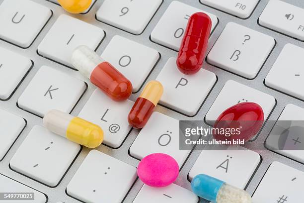 Tabletten auf Tastatur, Symbolfoto für Online Apotheken und Arzneimittelkosten