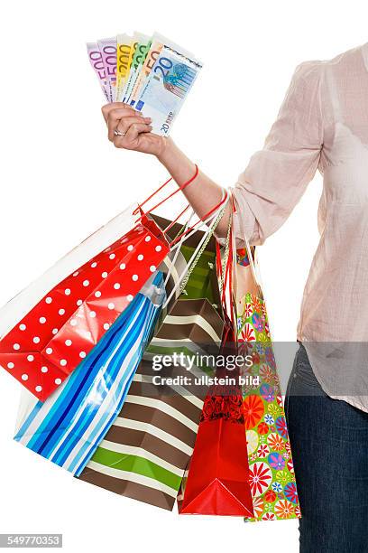 Eine junge Frau kommt mit vielen Einkaufstaschen vom Shopping zurück. Mit Euro Geldscheinen