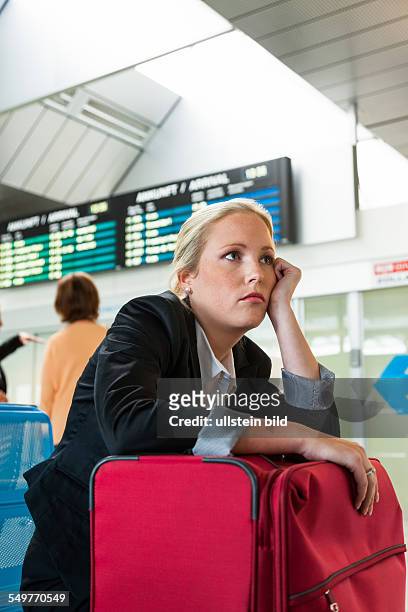 Geschäftsfrau wartet auf ihren Abflug am Flughafen. Symbolfoto für Wartezeiten, Flugausfälle und Streiks