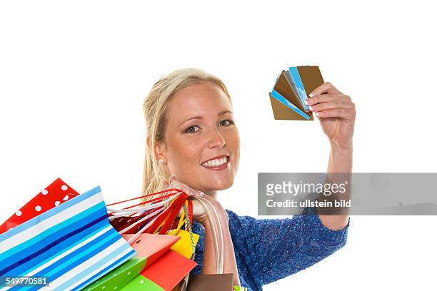 Eine junge Frau kommt mit vielen Einkaufstaschen vom Shopping zurück. Mit Kreditkarten und Plastikgeld