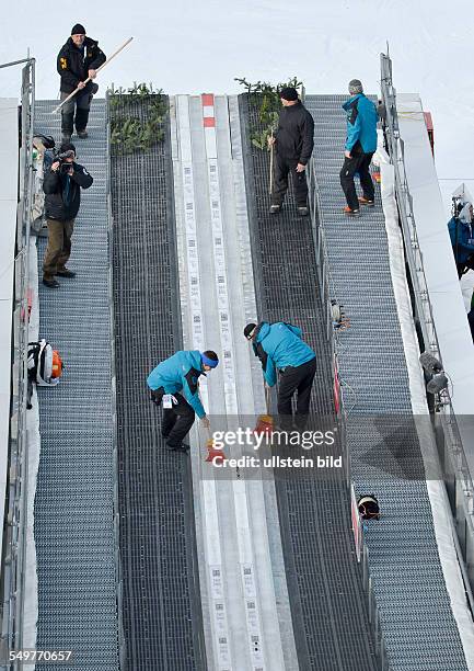 Helfer kehren die Anlaufspur sauber waehrend dem FIS Skispringen Weltcup bei der 61. Vierschanzentournee, am 1. Januar 2013 in Garmisch Partenkrichen.