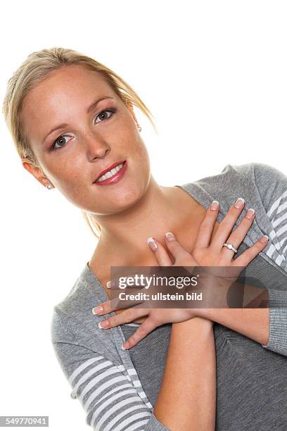 Eine junge Frau hält ihre Hände vor ihren Körper. Symbolfoto für Verinnerlichung und Harmonie