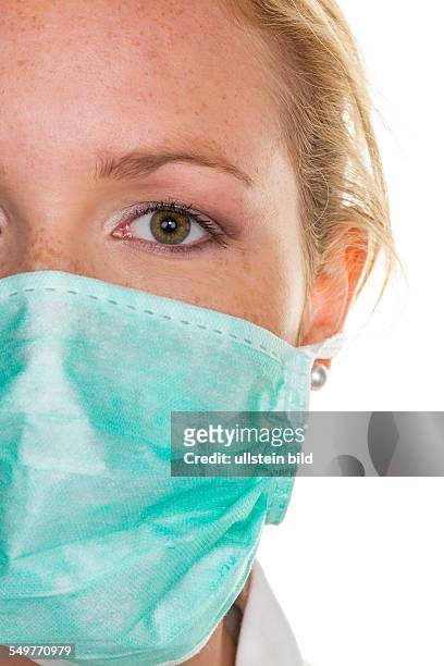 Eine junge Ärztin mit Mundschutz zum Schutz vor Infektionen und Ansteckungen von Krankheiten