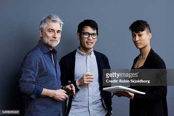 portrait of men and woman with pen and paper - three people stock pictures, royalty-free photos & images