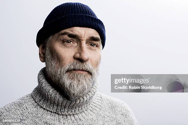 grey haired man in sweater wearing hat - bart stock-fotos und bilder