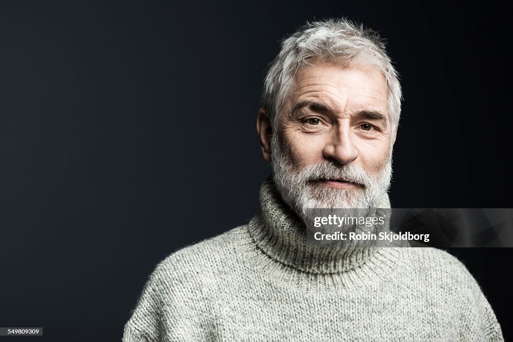 Portrait of mature grey haired man in sweater