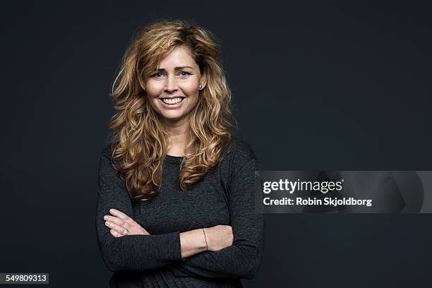 portrait of woman on grey backgrou with curly hair - blonde hair black background stock pictures, royalty-free photos & images