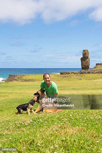 young man playing with dogs at easter island - easter_island stock pictures, royalty-free photos & images