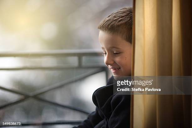 close up portrait of a smiling boy by window - só meninos - fotografias e filmes do acervo