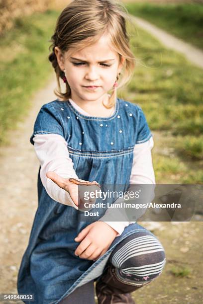 girl holding worm in hand - alexandra dost stock-fotos und bilder