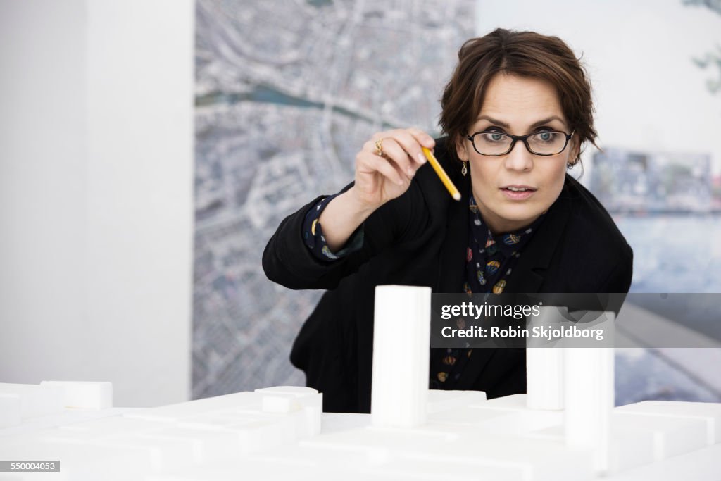 Woaman with scale model holding pencil