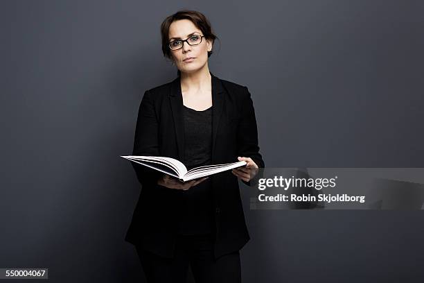 woman with glasses holding book - holding book stock pictures, royalty-free photos & images