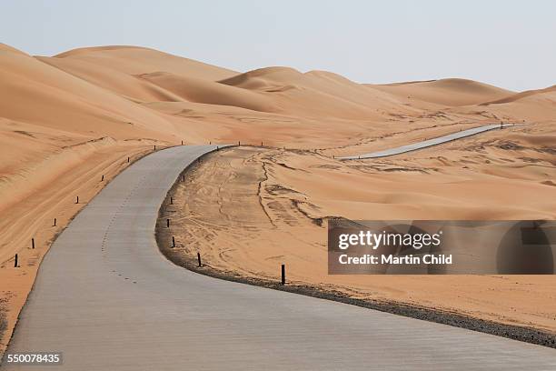 deserted road in the liwa desert near abu dhabi - stakes in the sand stock pictures, royalty-free photos & images