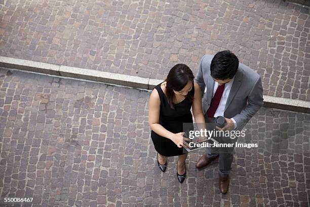 two asian business people using a digital tablet. - sydney from above stock pictures, royalty-free photos & images