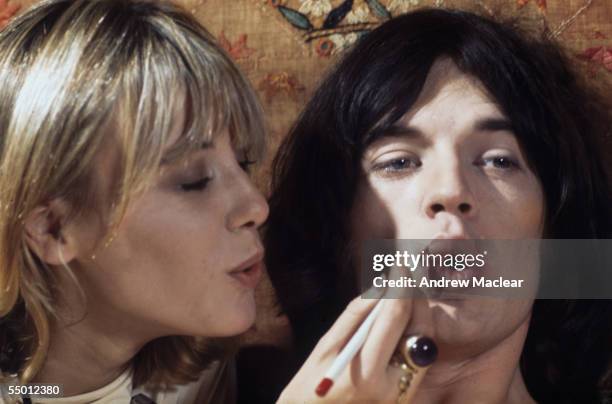 Anita Pallenberg helps Mick Jagger with his make-up on the set of Donald Cammell and Nicolas Roeg's psychological thriller, 'Performance', 1968.