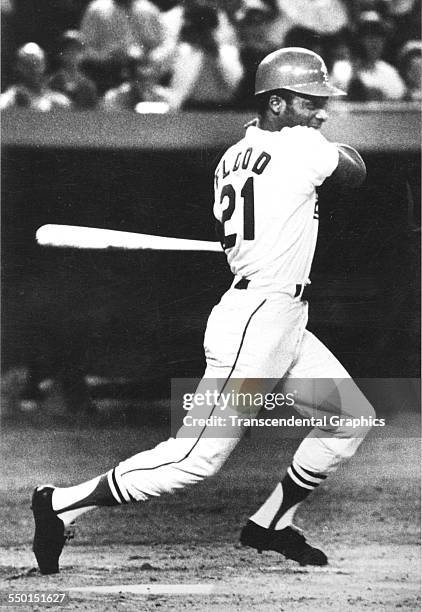 Photographic print of the baseball pioneer Curt Flood, who brought the game free agency, hits a line drive up the middle during a game at Busch...