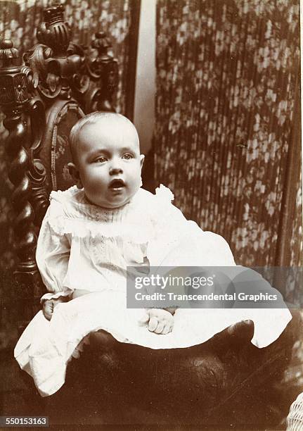 Very cute baby stares with interest at the camera, circa 1880.