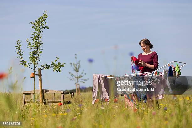 Woman, 35 years, drying the laundry in a rural garden