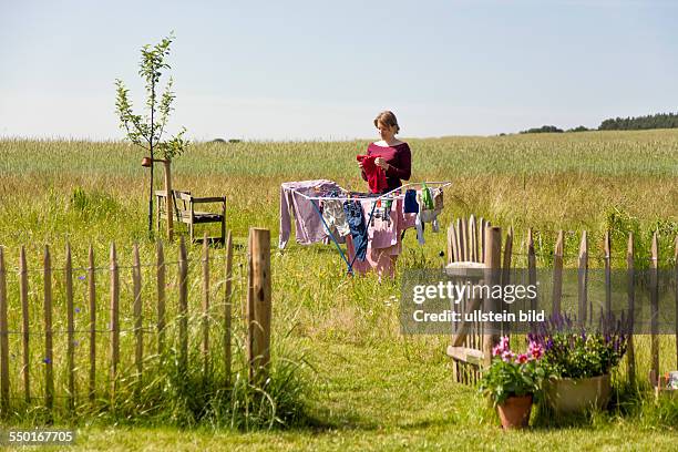 Woman, 35 years, drying the laundry in a rural garden