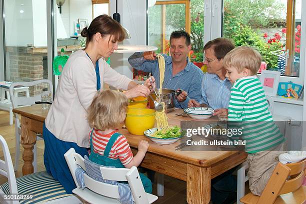 Scene family: father, mother and two children having lunch in the dining room. The grandfather is visiting and there's Spaghetti with fresh salad....