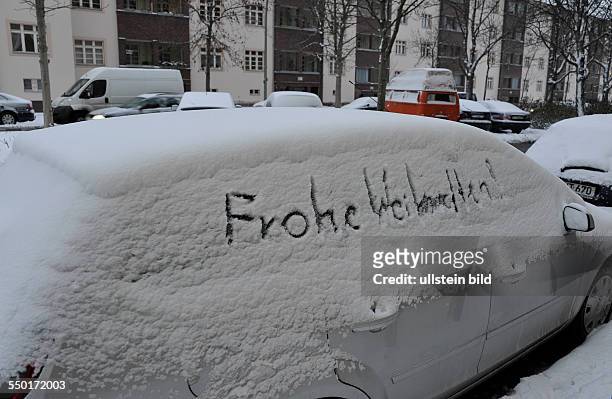 Schriftzug - FROHE WEIHNACHTEN - an einem eingeschneiten Auto in Berlin-Prenzlauer Berg
