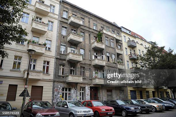 Unsanierter Altbau zwischen sanierten Wohnhäusern in der Kopenhagener Straße in Berlin-Prenzlauer berg