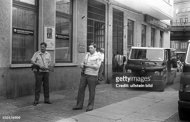 Monetary union of East and West Germany. Policemen from the GDR guarding a transport of money in front of a bank at Schoenhauser Allee