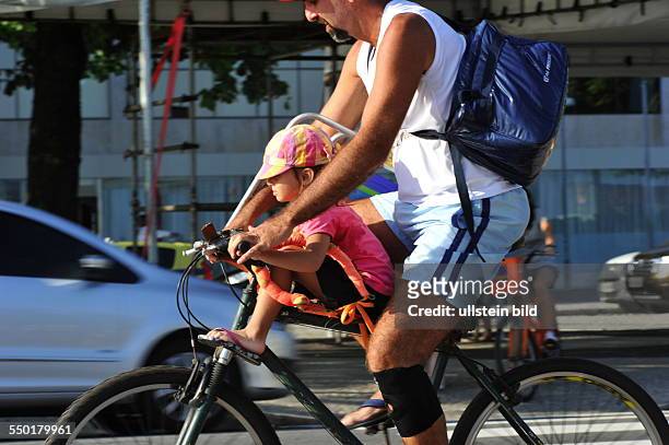 This Brazilian father drives with his son on the bike rack through the city traffic of Rio de Janeiro