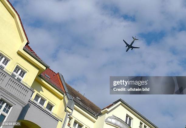 Berlin, Pankow, Flugzeug beim Landeanflug in den frühen Morgenstunden auf den Flughafen Tegel über einem Wohnhaus in der Hadlichstrasse