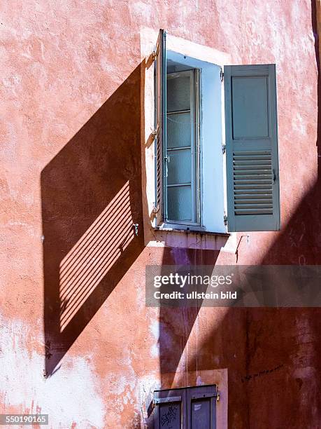 Ein rotes Haus mit Fenster und Fensterläden