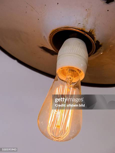 Energiesparlampe, Symbolfoto für Energiesparen, Ökologie, Umweltschutz. Glühfaden einer Glühbrine