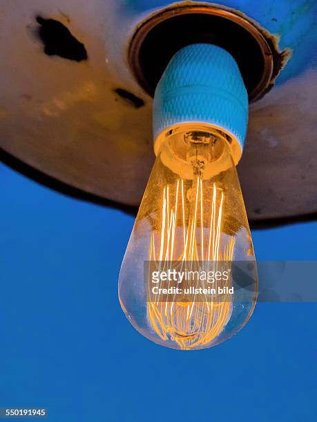 Energiesparlampe, Symbolfoto für Energiesparen, Ökologie, Umweltschutz. Glühfaden einer Glühbrine