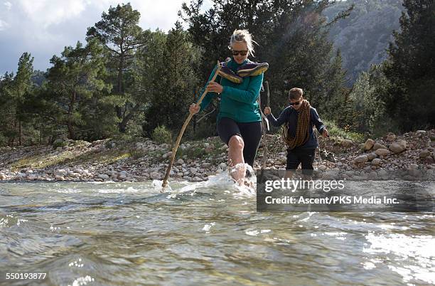 climbers cross river on route to climb destination - wading river stock pictures, royalty-free photos & images