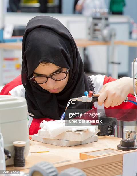 Berufe-Weltmeisterschaft Worldskills 2013 in Leipzig: arabische Goldschmiedin arbeitet an einem Werkstück